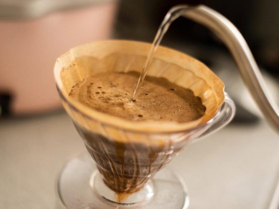 Hot water poured from a gooseneck kettle into a V60 dripper brewing specialty coffee